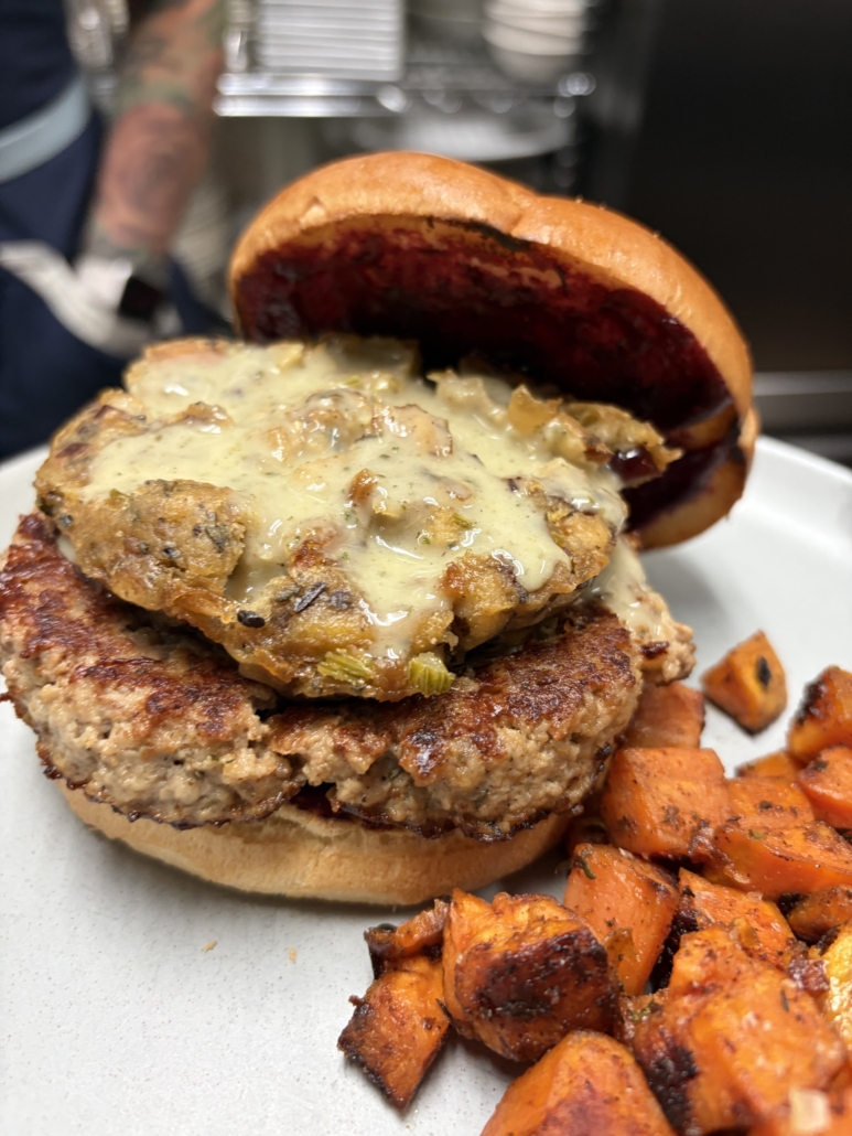Molly's Turkey Burger is an herbed turkey patty, spiced cranberry chutney, caramelized onion & sage stuffing, and a drizzle of house-made thyme-garlic gravy.
