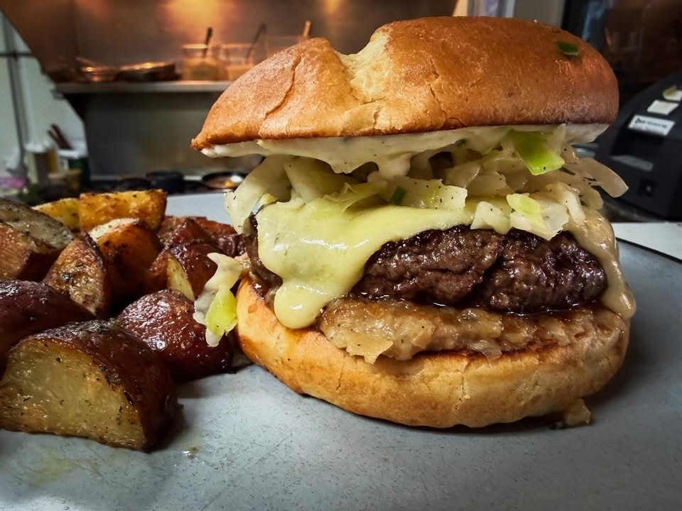 Grass-fed local beef, aged Irish cheddar, malty onion jam, horseradish chive cream, shaved spring cabbage on a toasted brioche bun… served with herb roasted baby red potatoes