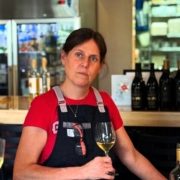 Molly Krinhop sitting near the bar with a glass of white wine